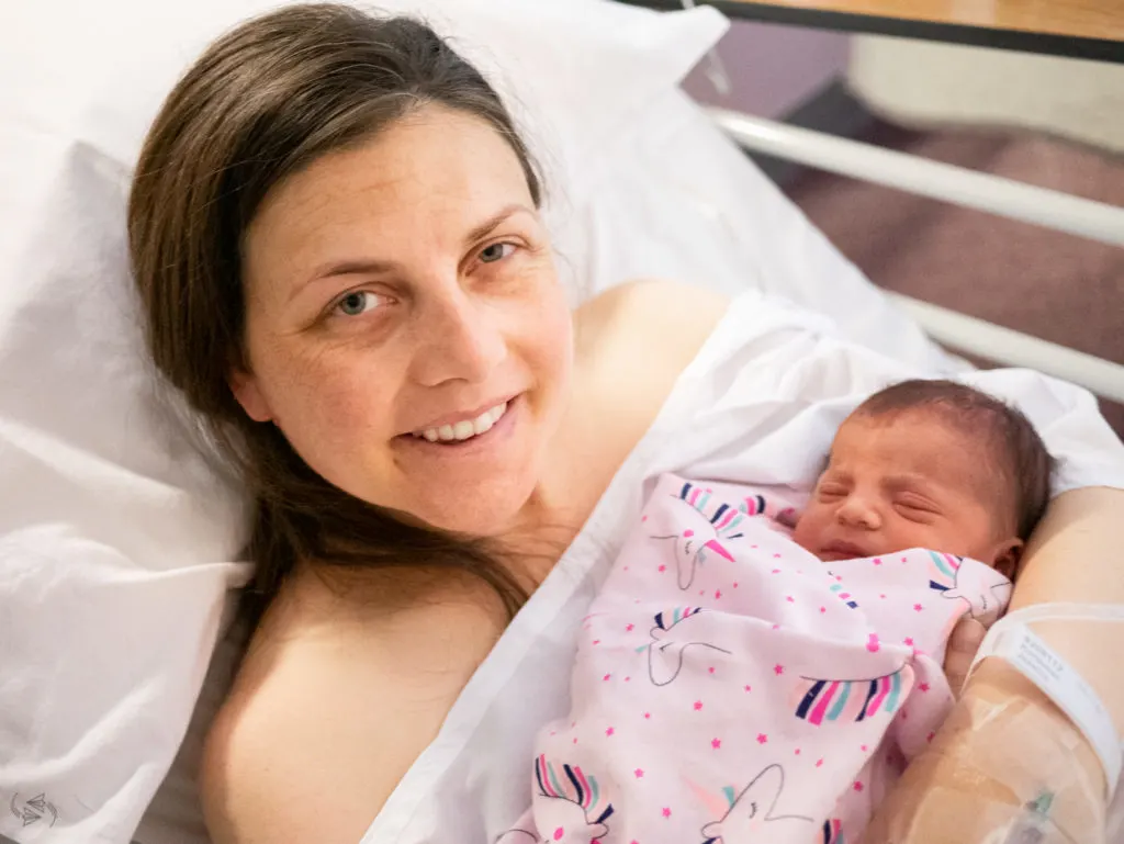 Me hold the baby in the maternity ward, who was now in her own clothes and wrapped in her own blanket covered in unicorns.