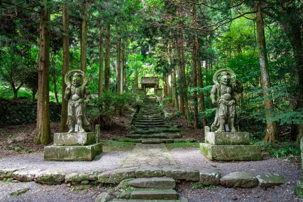 The pair of Nio Guardian statues on either side of the stone stairs leading up to Futagoji Temple in Oita.