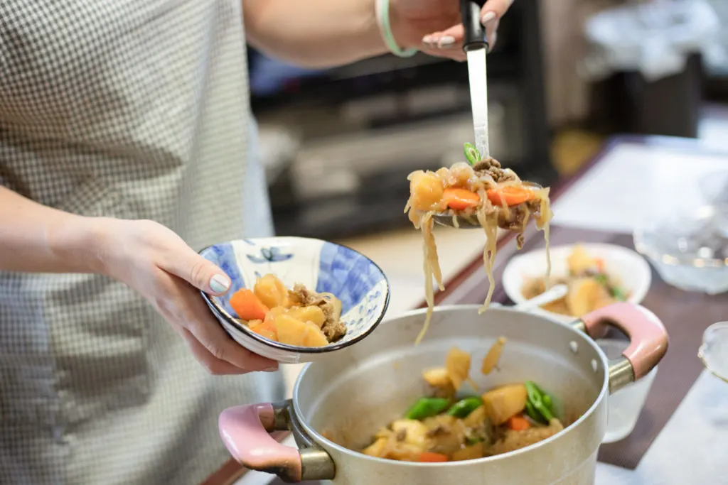 Serving up a noodle and vegetable dish made as part of the Cooking Experience on offer.