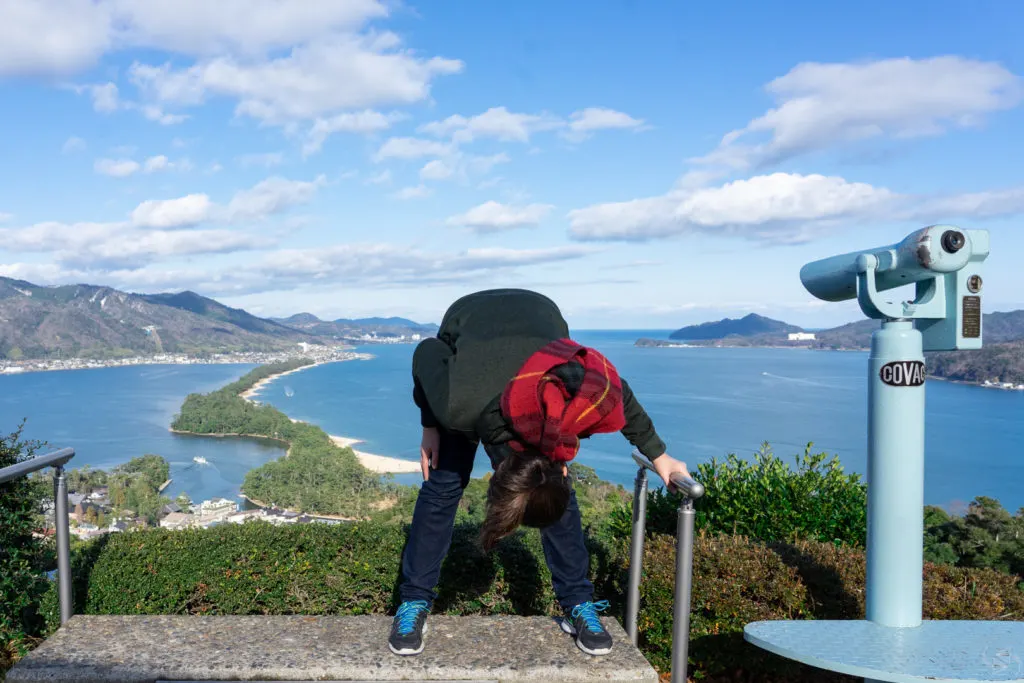 The author, Jessica, trying to see the dragon by looking at the view upside down.