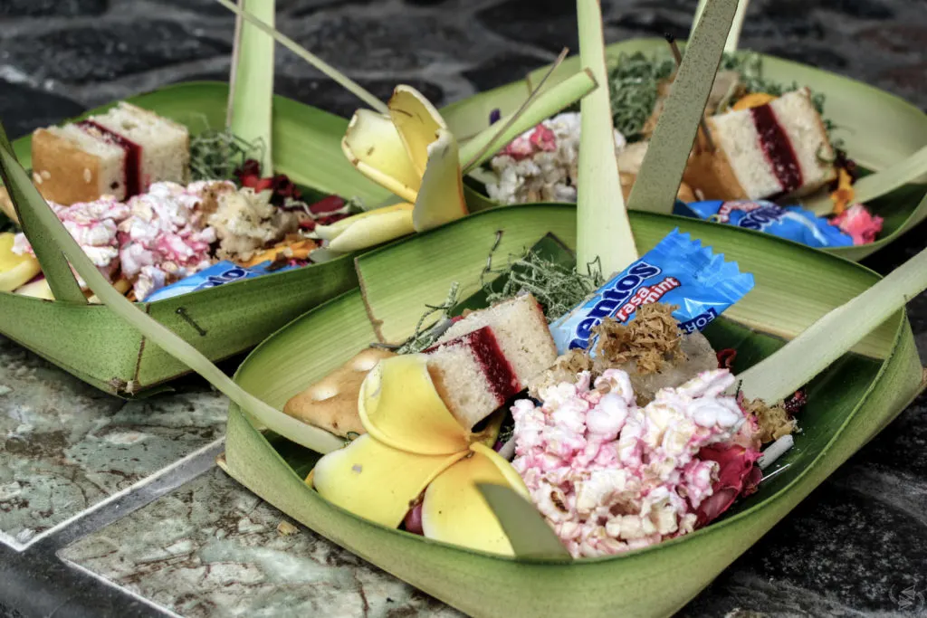 Balinese offerings to the gods, featuring flowers and sweets.