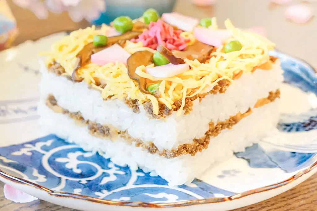 Barazushi on a plate, showing the two layers of rice, the mackerel 