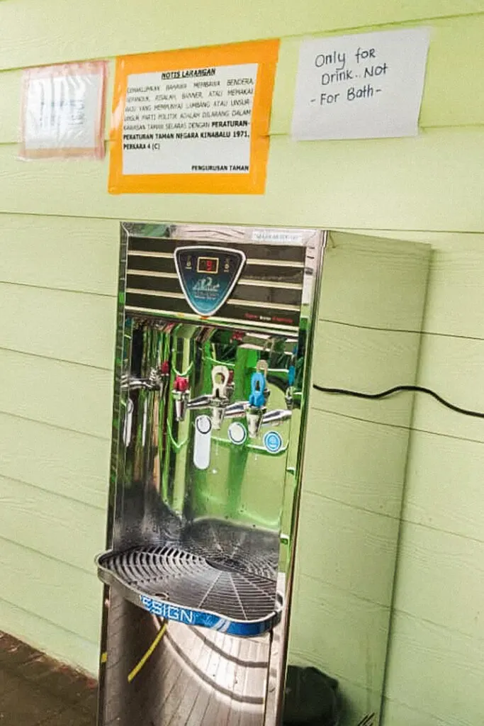 A picture of the commercial water filter outside Panalaban Hostel for drinking water on Mount Kinabalu. Above it is a sign that says the water is for drinking only and not for bathing.