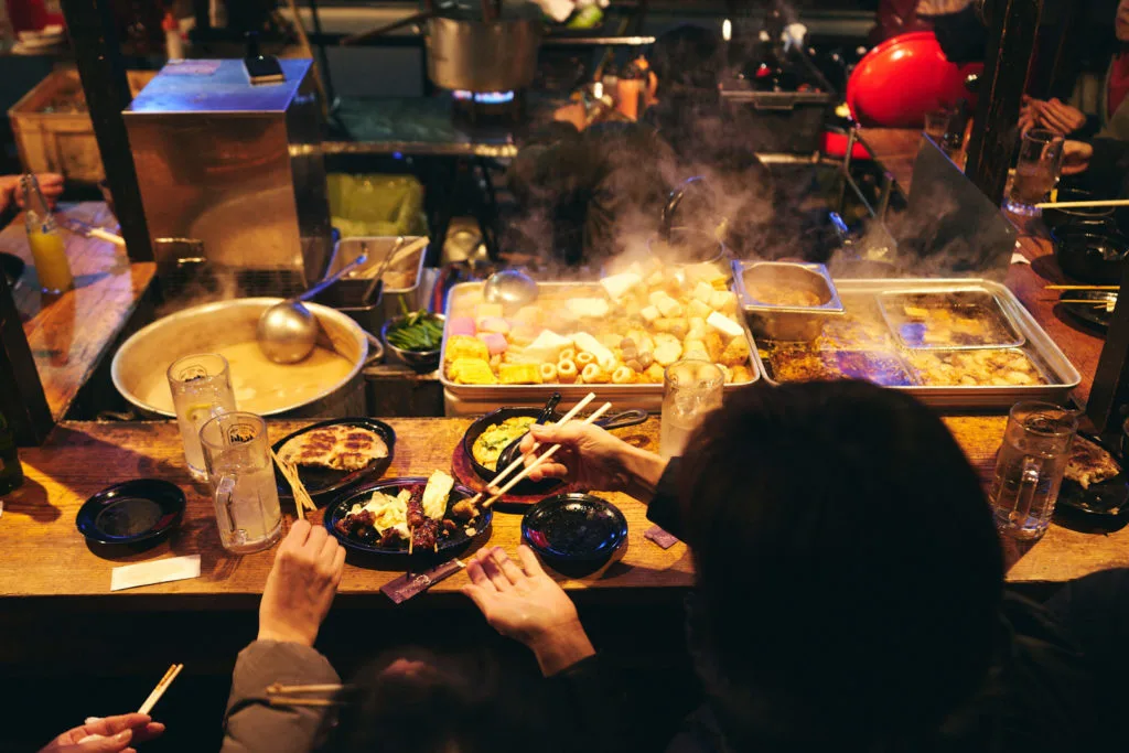 Customers tuck in to their steaming meal freshly made on the grill in front of them.