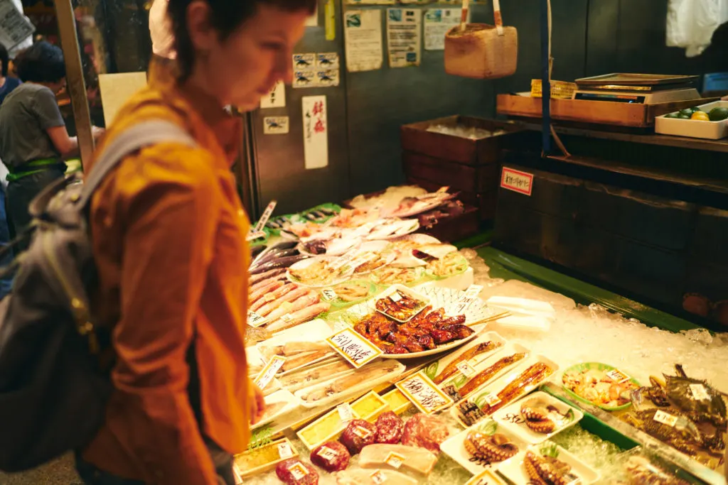 Woman peruses a fresh seafood stall at Tanga Market.