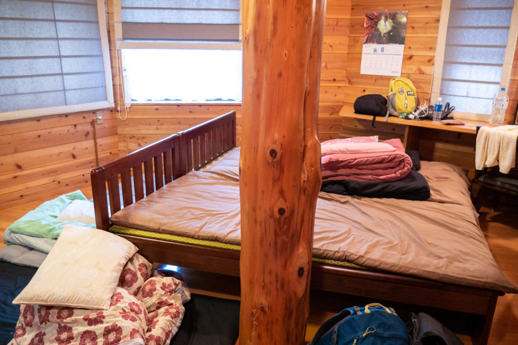 Two single beds with additional futon bedding on the floor.