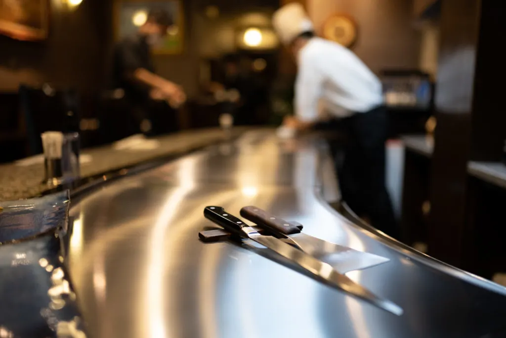 A knife and metal spatula sit on a hot plate prior to cooking kobe beef at a Japanese restaurant in Kobe.