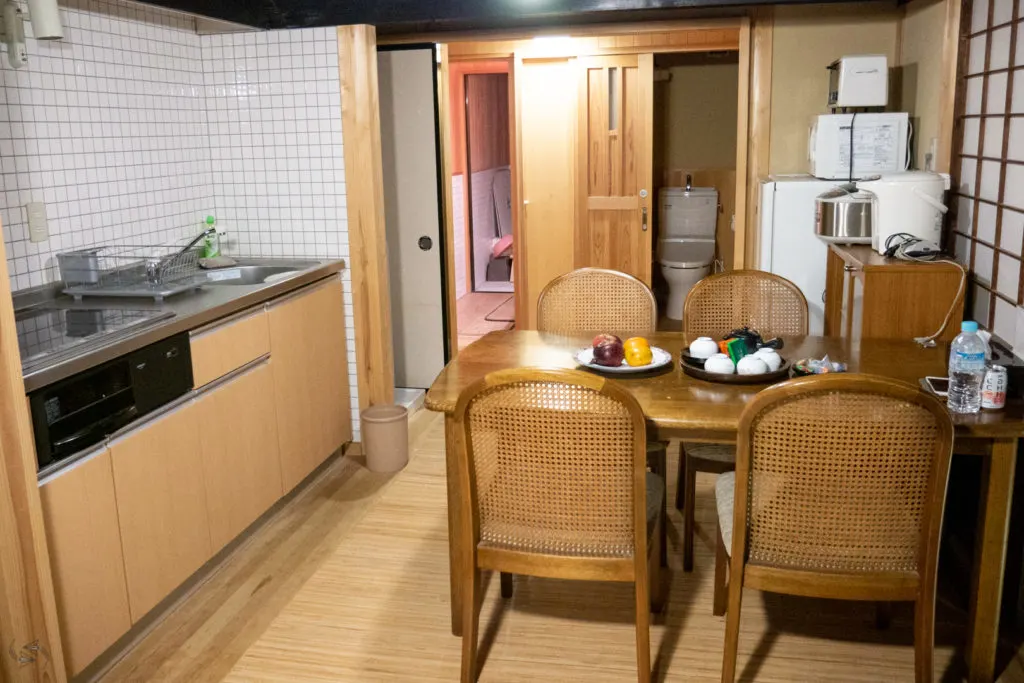 Traditional Japanese home in Shimane. The wooden kitchen and dining area can be seen in the foreground and the bathroom and toilet in the background. 