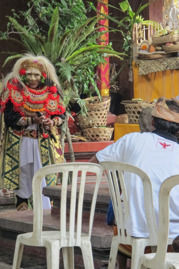 A traditional costumed performer dances as part of the ceremony.