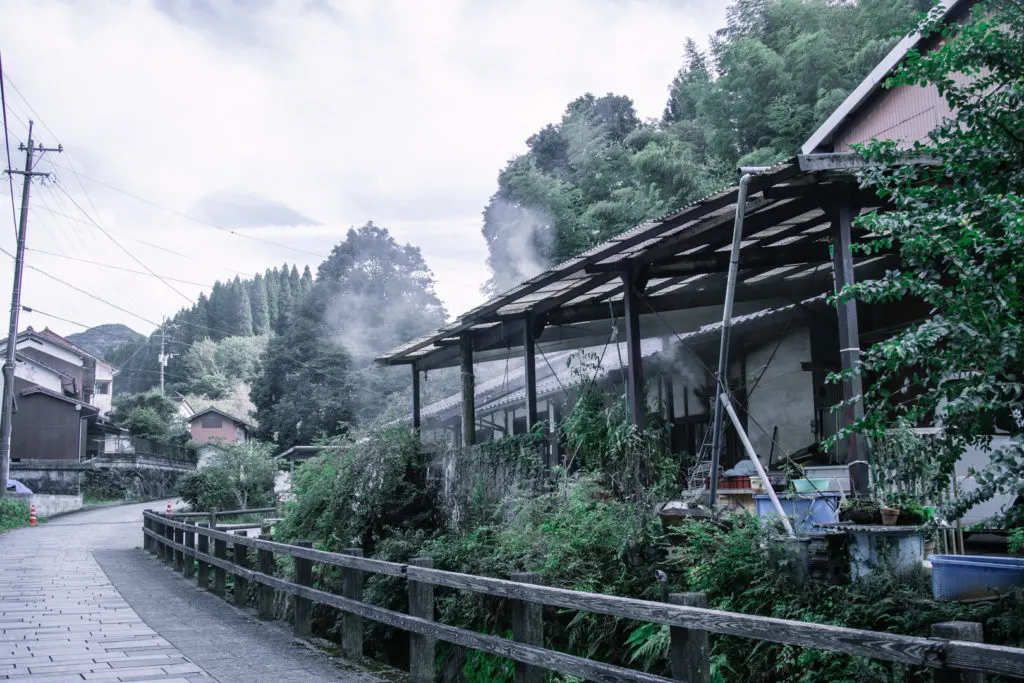 A calming and empty street scene in Toho Village with a residence to the right surrounded by greenery.