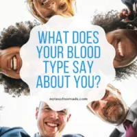A group of women and men of different ethnicities are huddled in a circle looking down at the camera in the middle. A white-colored icon in the center with blue text reads, 'What does your blood type say about you?' In black text below it, 'notesofnomads.com'.
