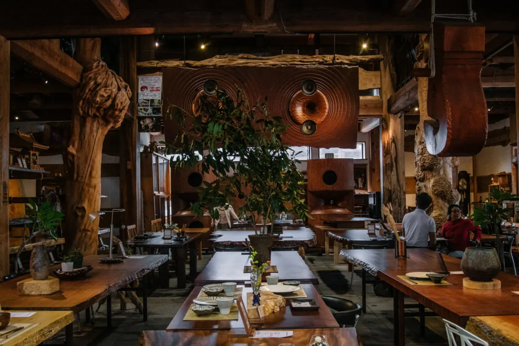 Long dining tables in ornate wood shop in Toho Village.